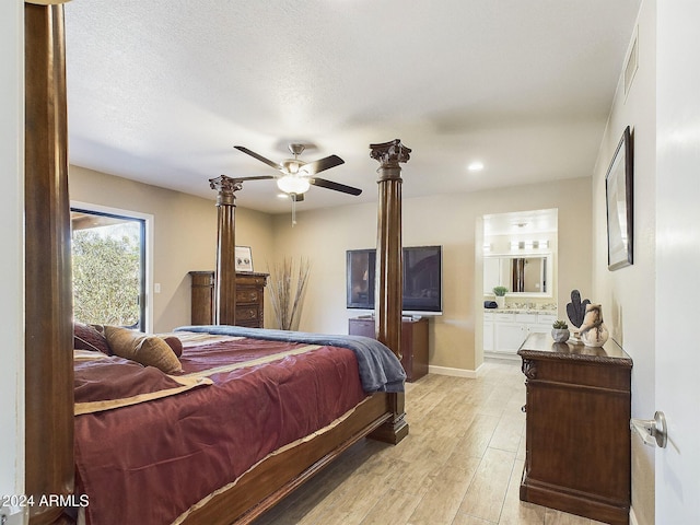 bedroom with ensuite bathroom, ceiling fan, light hardwood / wood-style floors, and a textured ceiling