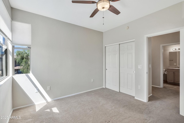 unfurnished bedroom featuring baseboards, a closet, and light colored carpet