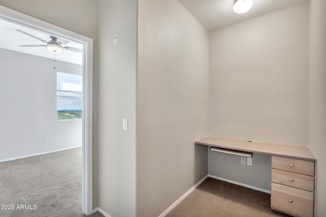 unfurnished office with carpet, baseboards, and ceiling fan