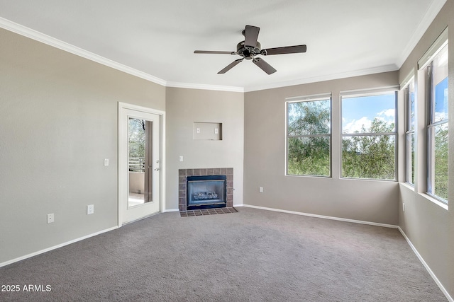 unfurnished living room featuring ceiling fan, a wealth of natural light, crown molding, and a tiled fireplace