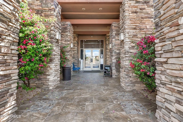 doorway to property featuring french doors and stone siding