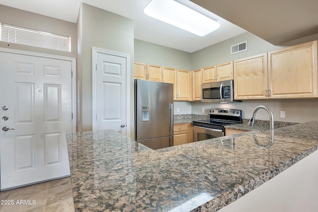 kitchen with visible vents, light brown cabinetry, stone countertops, and appliances with stainless steel finishes