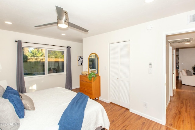 bedroom with visible vents, baseboards, a ceiling fan, light wood-style flooring, and a closet