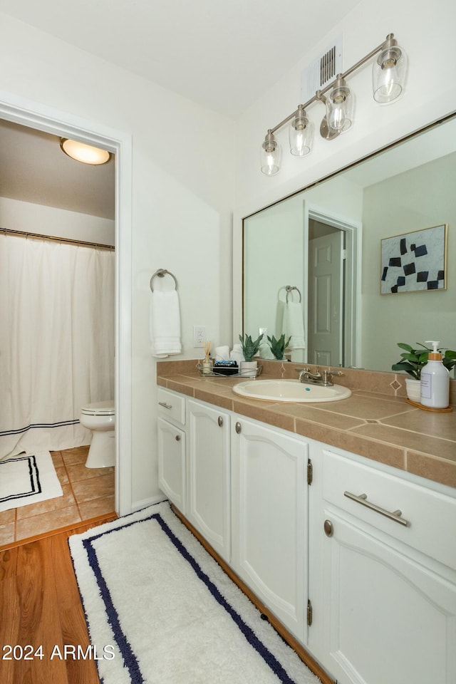 full bathroom featuring toilet, wood finished floors, and vanity