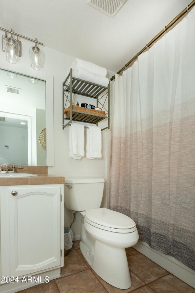 bathroom featuring toilet, vanity, visible vents, and tile patterned floors