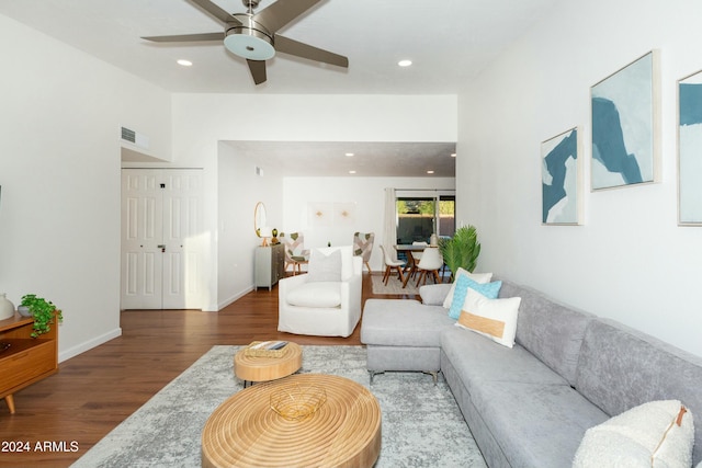 living room featuring recessed lighting, wood finished floors, visible vents, baseboards, and vaulted ceiling