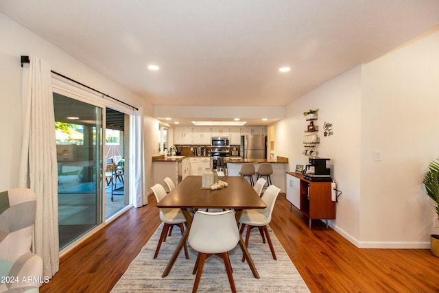 dining room featuring baseboards, dark wood-type flooring, and recessed lighting