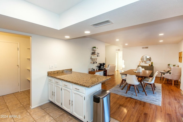 kitchen featuring recessed lighting, white cabinets, visible vents, and a peninsula