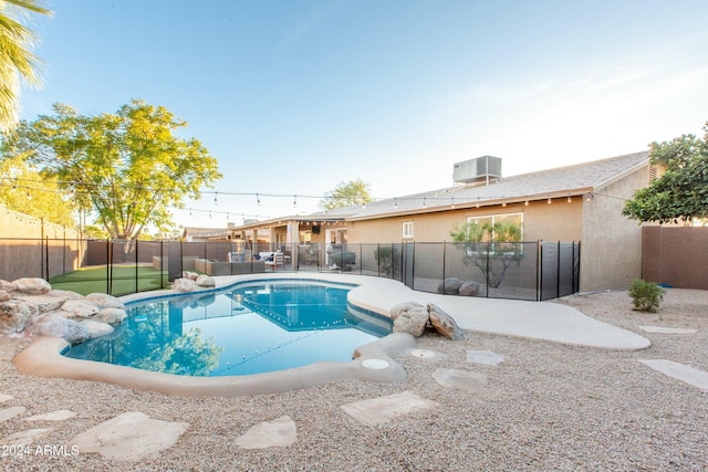 view of pool featuring a fenced backyard, a fenced in pool, and central AC