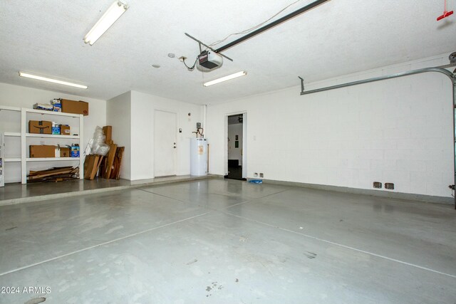 garage with a garage door opener, concrete block wall, and water heater