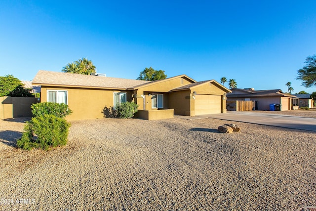 single story home with an attached garage, driveway, fence, and stucco siding