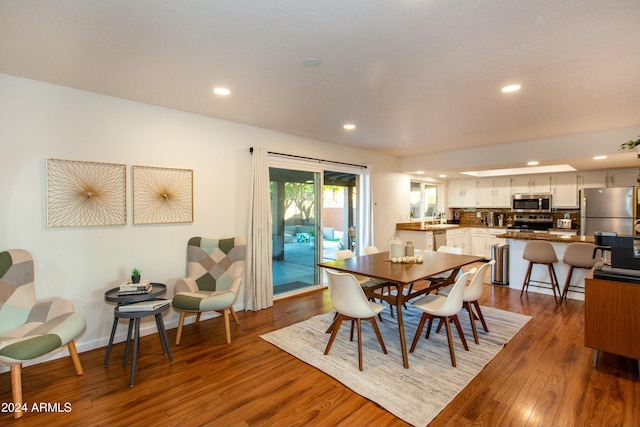 dining room featuring baseboards, dark wood finished floors, and recessed lighting