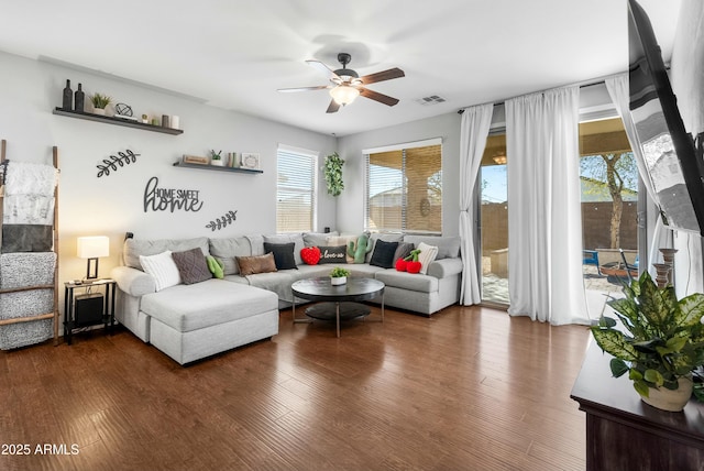 living area with ceiling fan, visible vents, and wood finished floors