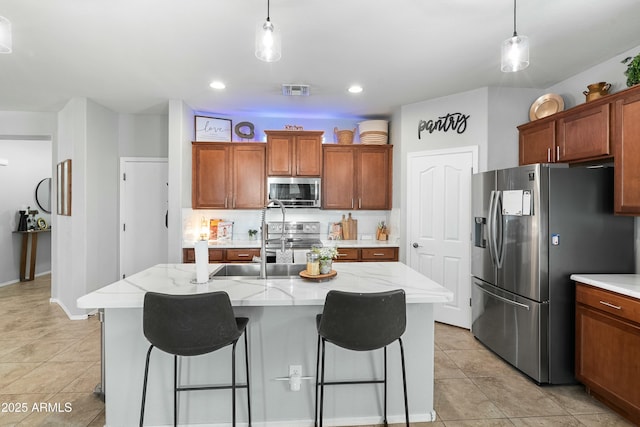 kitchen with decorative light fixtures, backsplash, stainless steel appliances, and brown cabinetry