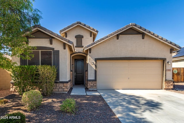 1952 N 212th Ln, Buckeye, AZ 85396 - view of front of home with fence, stone siding, a garage, stucco siding, and concrete driveway