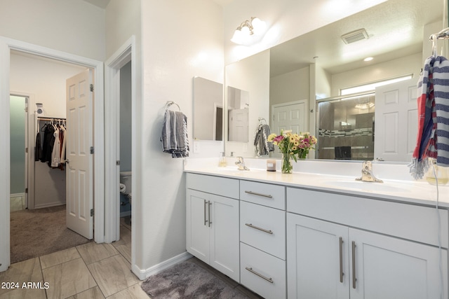 bathroom with vanity, walk in shower, and toilet