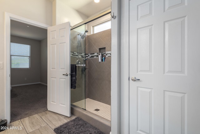 bathroom with a healthy amount of sunlight and a shower with shower door