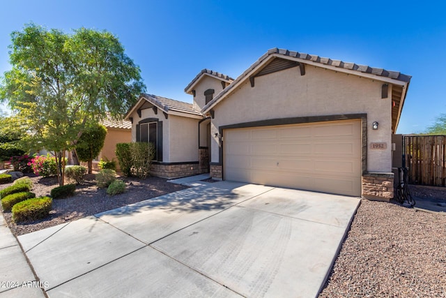 1952 N 212th Ln, Buckeye, AZ 85396 - mediterranean / spanish house featuring a garage, stone siding, stucco siding, a tiled roof, and driveway