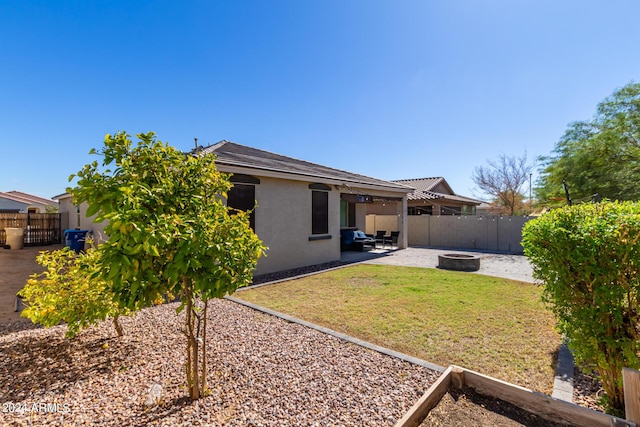 1952 N 212th Ln, Buckeye, AZ 85396 - exterior space featuring a fire pit, a patio, a fenced backyard, stucco siding, and a lawn