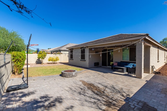 back of house with an outdoor living space with a fire pit and a patio