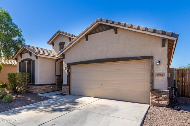 1952 N 212th Ln, Buckeye, AZ 85396 - view of front of home featuring an attached garage, stucco siding, stone siding, and concrete driveway