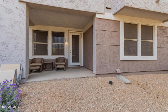 entrance to property featuring stucco siding