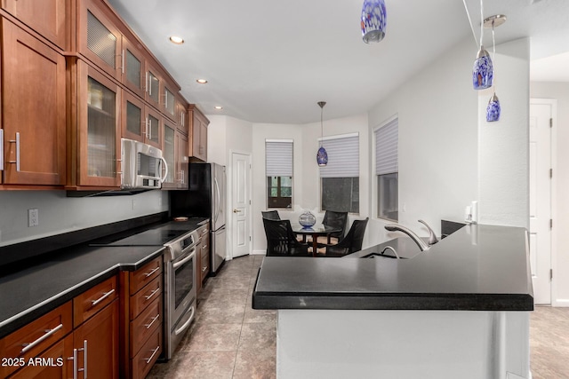 kitchen featuring dark countertops, decorative light fixtures, a peninsula, stainless steel appliances, and recessed lighting