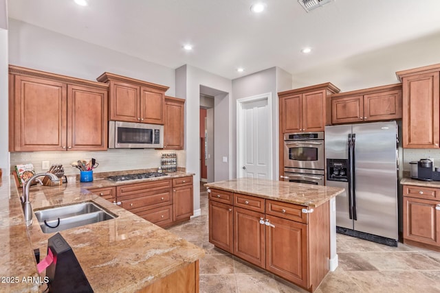 kitchen with light stone counters, sink, and appliances with stainless steel finishes