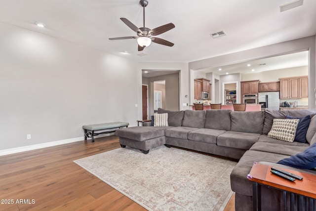 living room featuring ceiling fan and light wood-type flooring