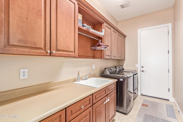 clothes washing area featuring independent washer and dryer, cabinets, sink, and light tile patterned floors