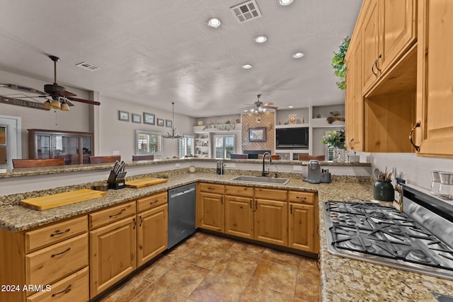 kitchen with light stone counters, appliances with stainless steel finishes, sink, and kitchen peninsula