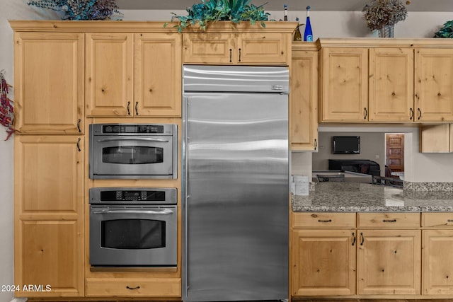 kitchen featuring stainless steel built in fridge, stone countertops, and light brown cabinetry