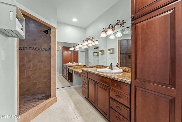 bathroom with vanity, tiled shower, and tile patterned floors