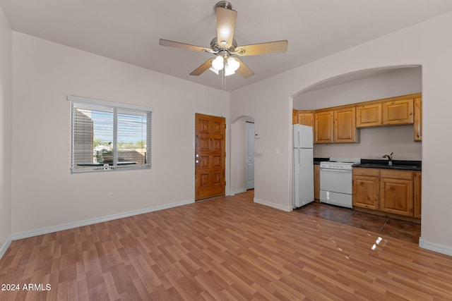 kitchen with light hardwood / wood-style floors, white fridge, sink, and ceiling fan