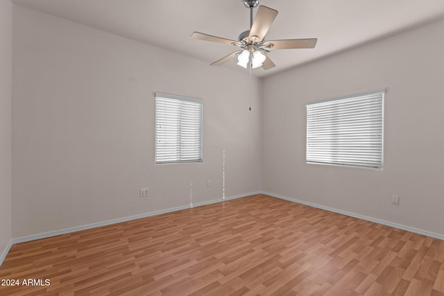 spare room with ceiling fan and light wood-type flooring