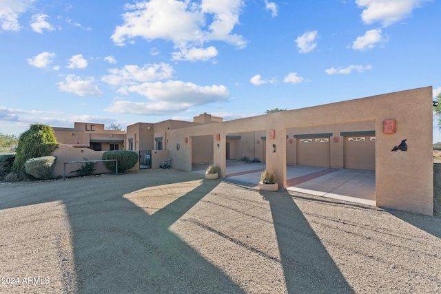 pueblo revival-style home with a garage