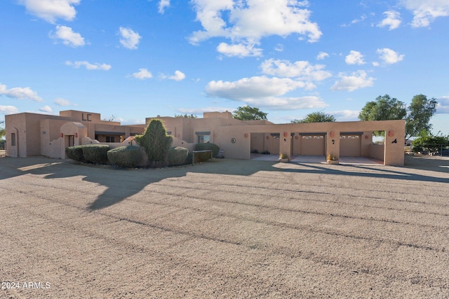 pueblo-style home featuring a garage