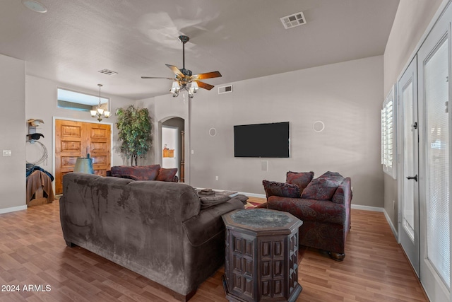 living room featuring light hardwood / wood-style flooring and ceiling fan with notable chandelier