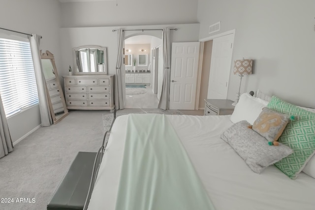 bedroom featuring light colored carpet and connected bathroom