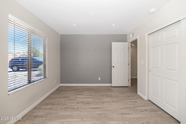 6457 E Encanto St, Mesa, AZ 85205 - unfurnished bedroom featuring light wood finished floors, a closet, baseboards, and visible vents