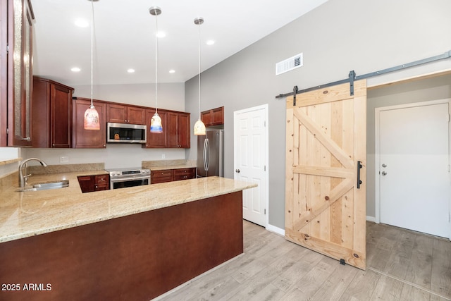 6457 E Encanto St, Mesa, AZ 85205 - kitchen featuring light wood-style floors, stainless steel appliances, a peninsula, and a sink