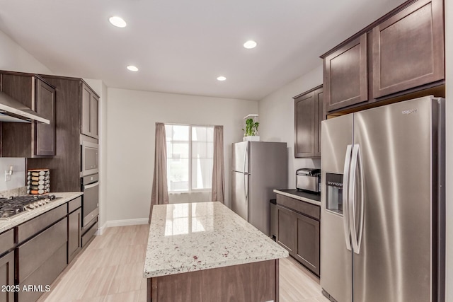 2881 N Riverside Dr, Florence, AZ 85132 - kitchen with stainless steel appliances, recessed lighting, dark brown cabinets, a center island, and light stone countertops