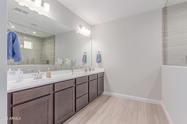 2881 N Riverside Dr, Florence, AZ 85132 - bathroom featuring a tile shower, double vanity, and baseboards