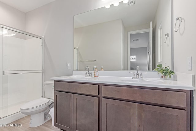 2881 N Riverside Dr, Florence, AZ 85132 - bathroom featuring toilet, a stall shower, double vanity, and wood finished floors