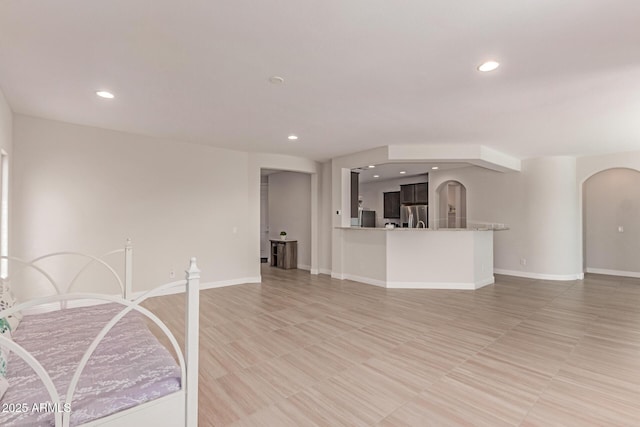 2881 N Riverside Dr, Florence, AZ 85132 - unfurnished living room with arched walkways, recessed lighting, and baseboards