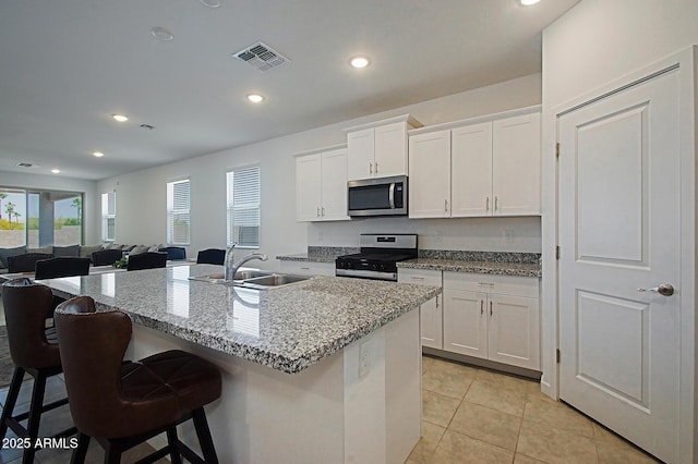 41600 W Dusty Creek Dr, Maricopa, AZ 85138 - kitchen featuring a breakfast bar area, stainless steel appliances, a sink, white cabinetry, and visible vents