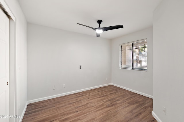 spare room with dark hardwood / wood-style flooring and ceiling fan