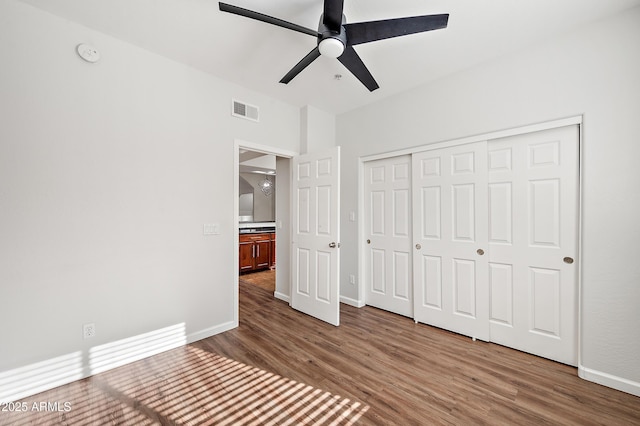 unfurnished bedroom with hardwood / wood-style flooring, ceiling fan, and a closet