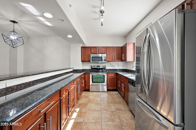 kitchen with rail lighting, dark stone countertops, decorative light fixtures, light tile patterned floors, and appliances with stainless steel finishes