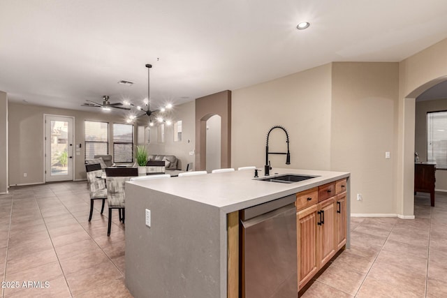 kitchen featuring arched walkways, light tile patterned floors, a sink, stainless steel dishwasher, and an inviting chandelier